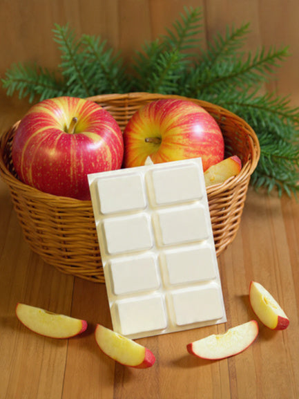 Apple Pickin’ wax melt bar on wood floor with applies in a basket and greenery -  Ember Haven Candles